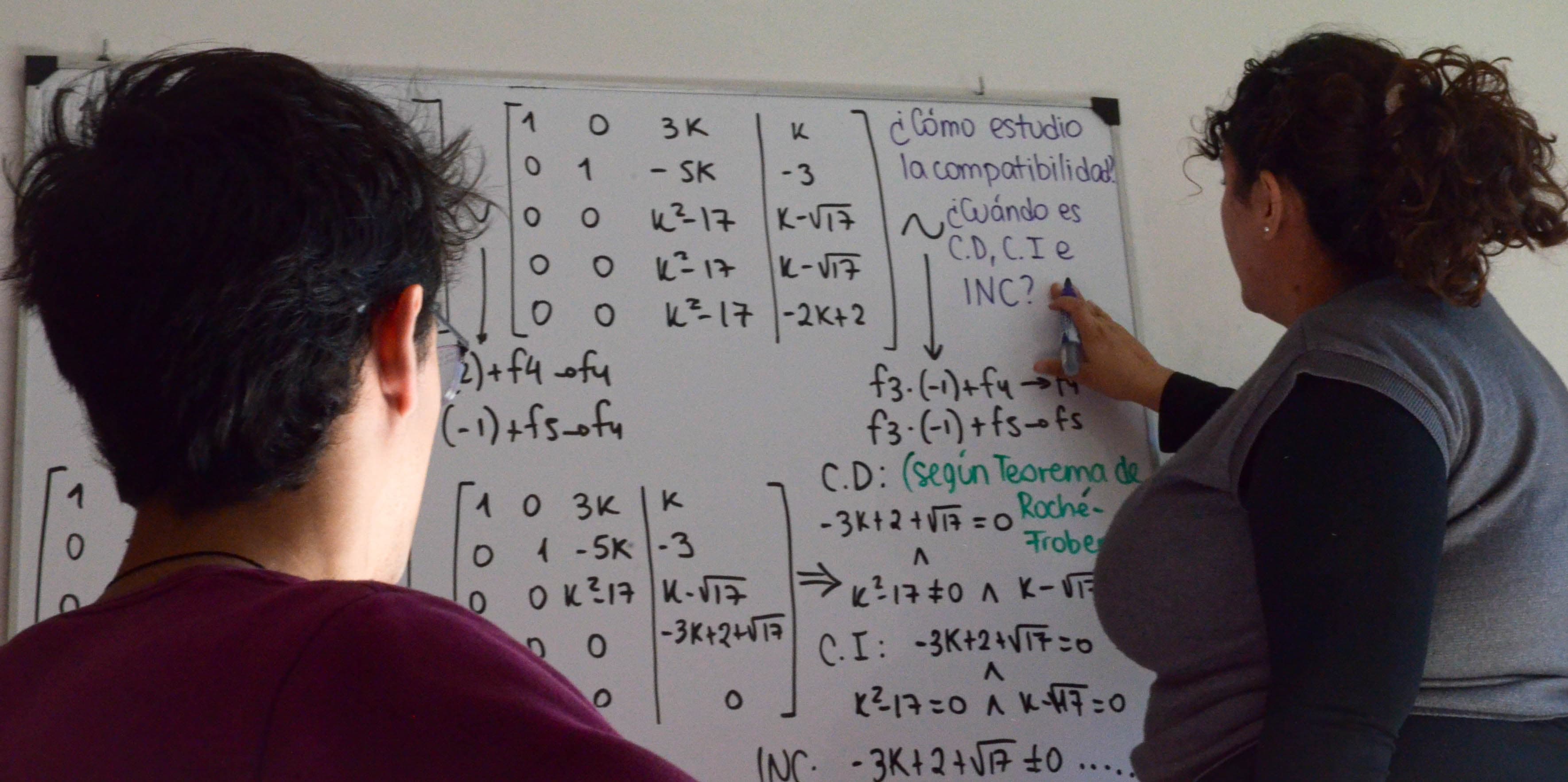 Estudiante escribiendo en pizarra